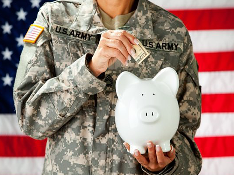 Picture of a servicemember putting money into a piggy bank