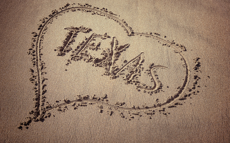 Picture of the word Texas and heart drawn on the beach sand