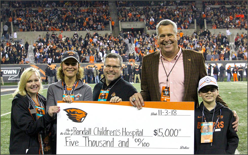 Group of people on field receiving a check.